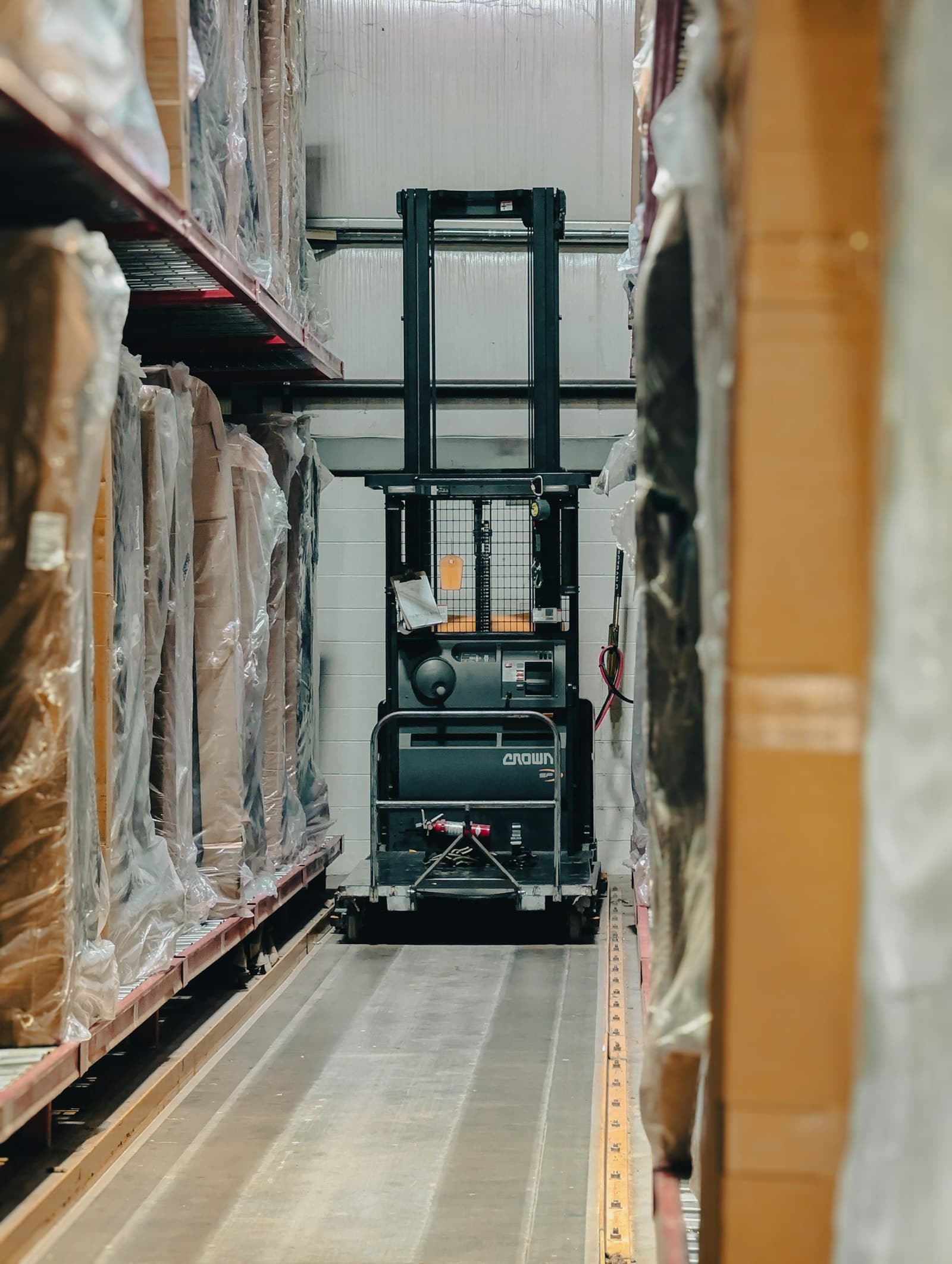Forklift moving palletized surplus equipment inside a warehouse